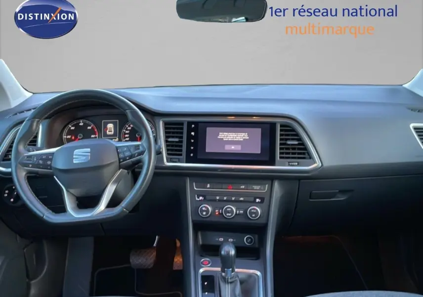 Vue intérieure frontale du tableau de bord et volant noir du SEAT Ateca 2022 avec écran tactile central et levier de vitesse automatique.