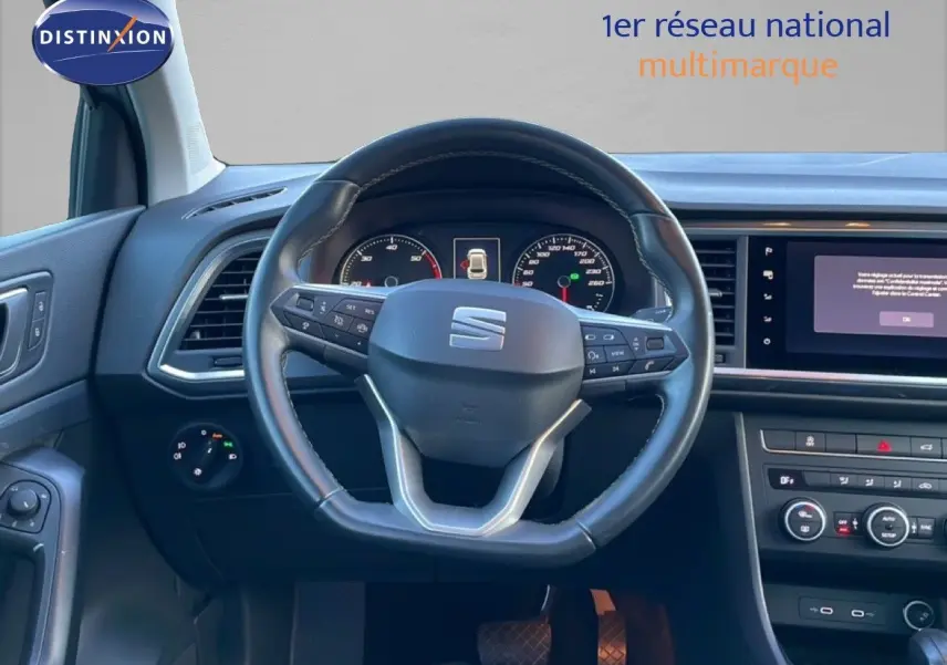 Vue intérieure centrée sur le volant cuir noir du SEAT Ateca 2022, avec tableau de bord et écran multimédia visibles.