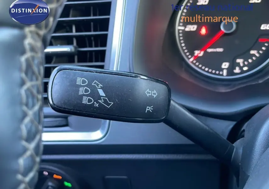 Gros plan sur la commande de clignotants à gauche du volant dans l’habitacle d’un SEAT Ateca argent 2022.