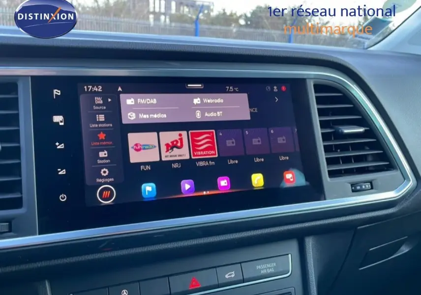 Écran tactile central allumé du tableau de bord d’un SEAT Ateca argent, avec commandes et aérateurs visibles.