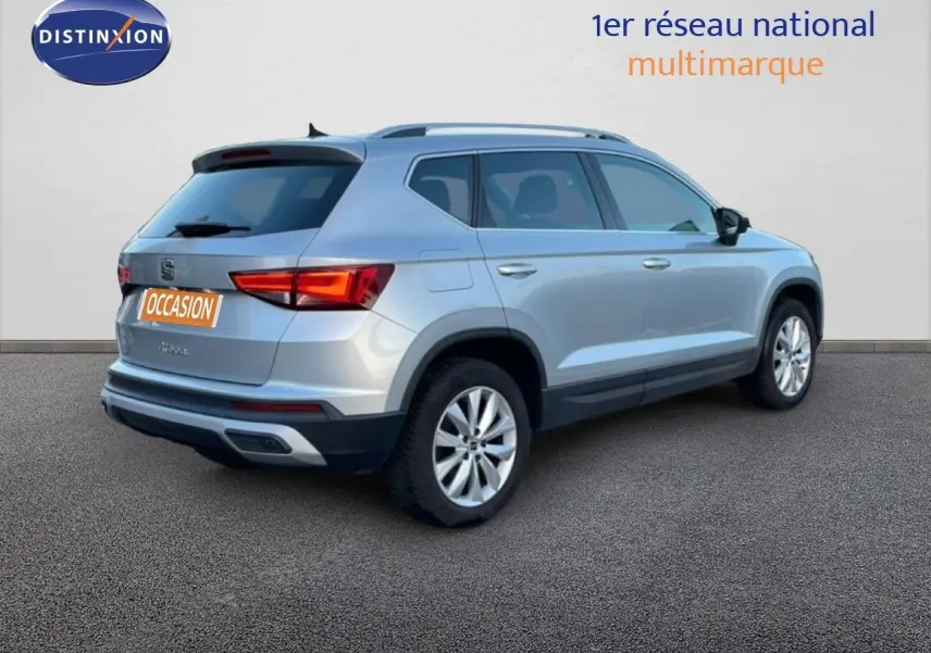 Vue 3/4 arrière droite d'un SEAT Ateca 2022 argent Reflex Metal avec jantes alliage et feux LED allumés.