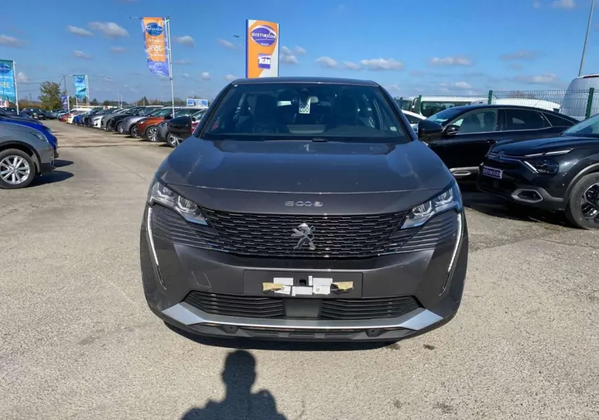 Vue avant d'un Peugeot 5008 gris platinium métallisé, avec calandre noire et feux LED distinctifs.