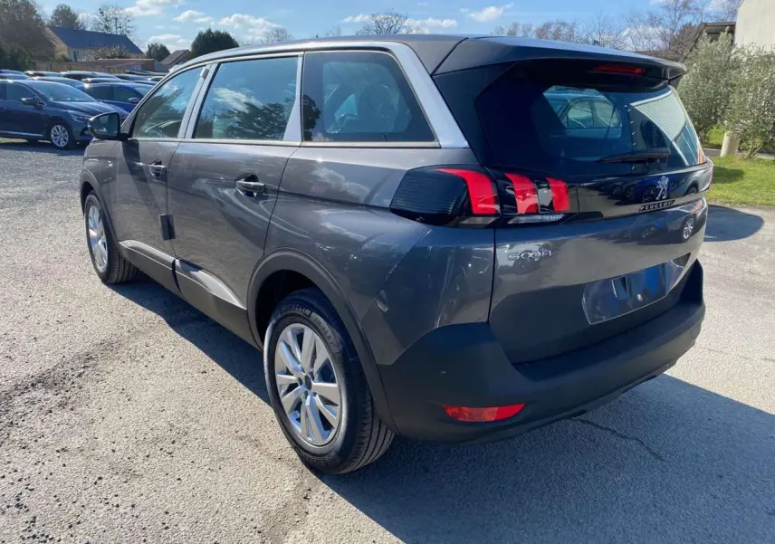 Vue 3/4 arrière droit d’un Peugeot 5008 gris platinium métallisé avec feux arrière LED et jantes alliage 17 pouces.