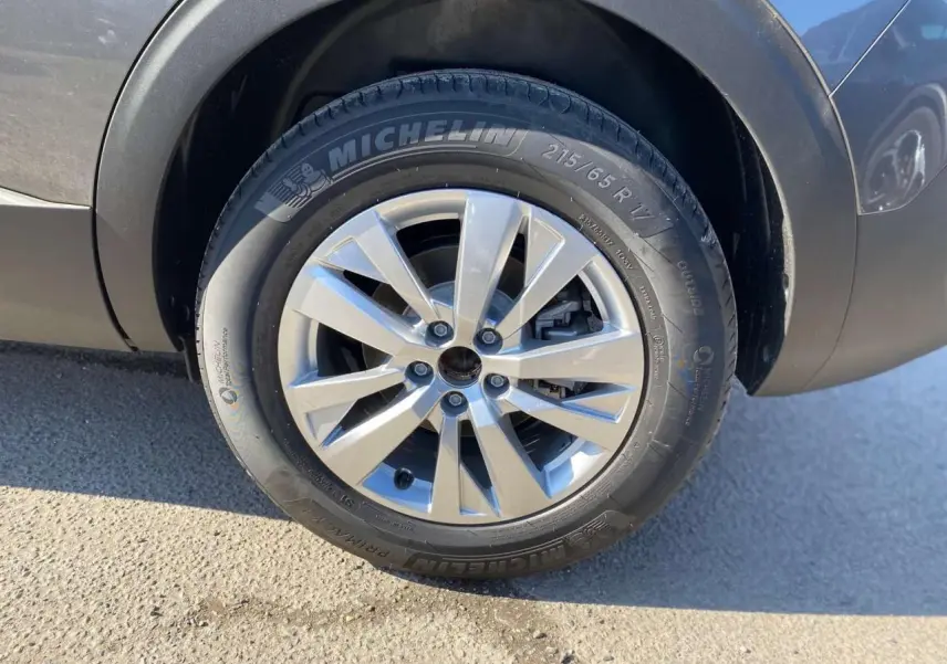 Gros plan sur la roue avant droite d’un Peugeot 5008 gris platinium métal avec jante alliage 17 pouces Chicago.