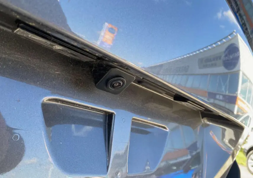 Gros plan sur la caméra de recul intégrée à la malle arrière du Peugeot 5008 gris platinium métallisé.