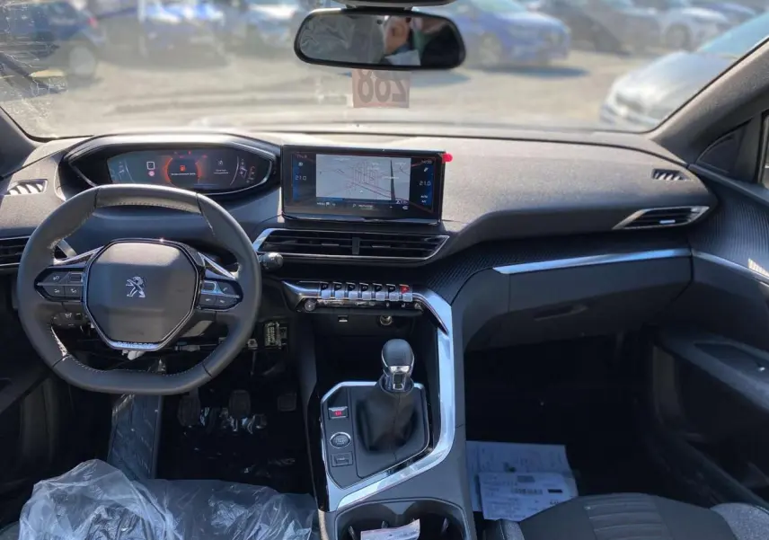 Vue intérieure avant du Peugeot 5008 gris platinium, mettant en valeur le tableau de bord numérique et l’écran tactile central.