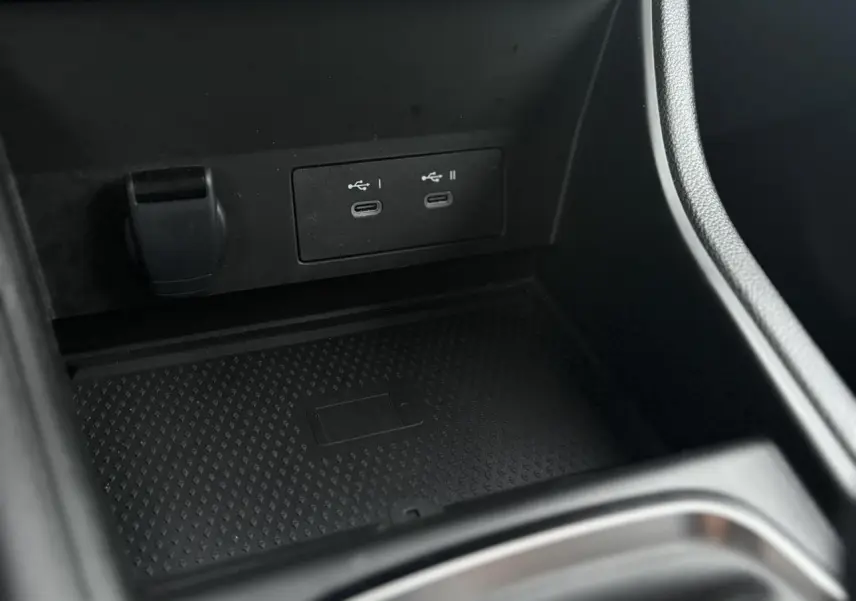 Gros plan sur la console centrale du Renault Captur TCE 100 Techno 2025, montrant les ports USB-C doubles et un espace de rangement noir.