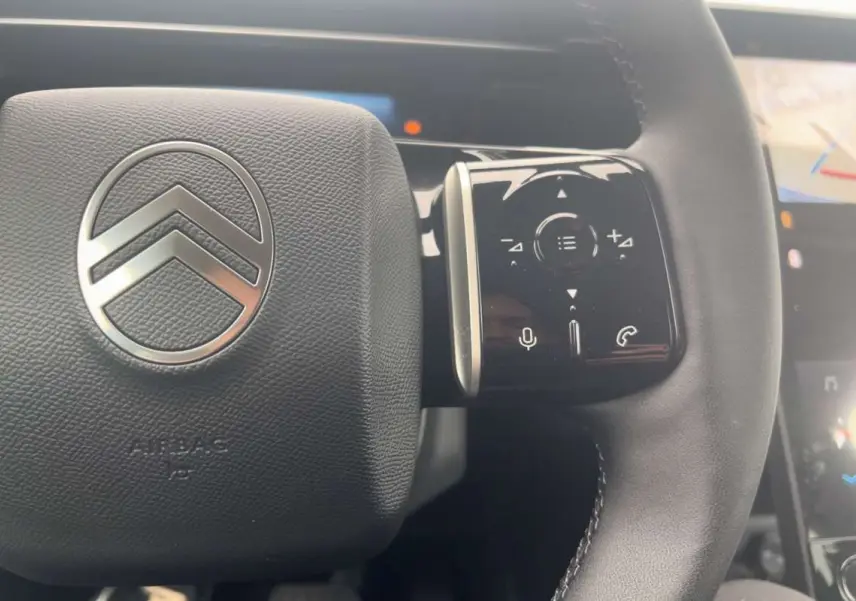 Gros plan sur le volant cuir noir du Citroën C5 Aircross Hybrid 145 Plus PK Drive avec commandes multifonctions.