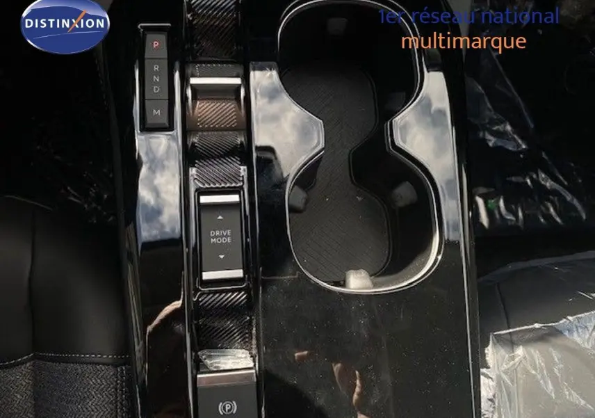 Vue rapprochée de la console centrale noire brillante avec commandes de boîte auto et porte-gobelets du Citroën C5 X gris Thorium.