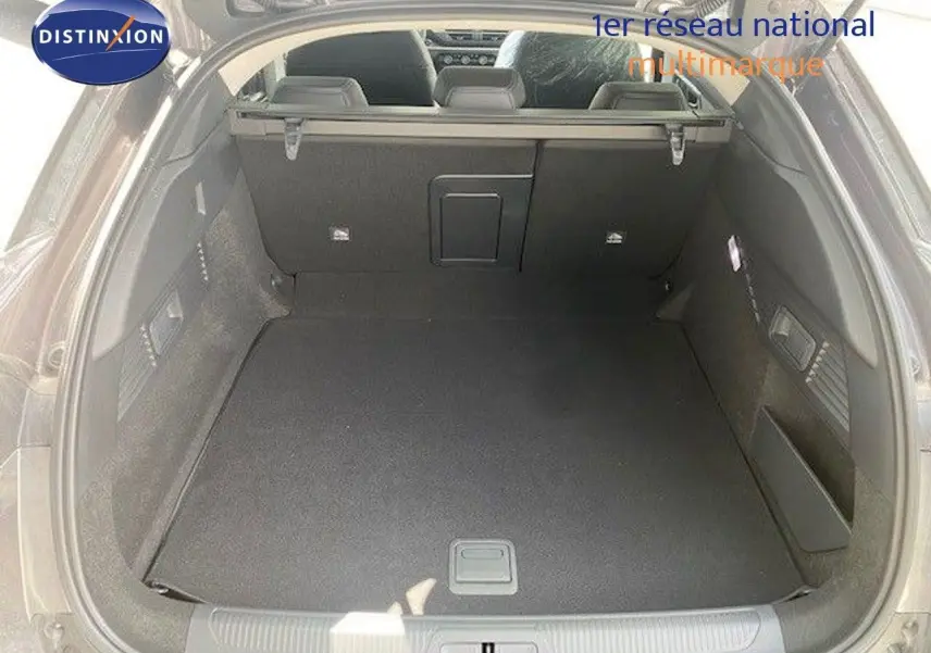 Coffre ouvert vu de l’arrière d’une Citroën C5 X gris thorium métal, espace de chargement spacieux et bien fini.