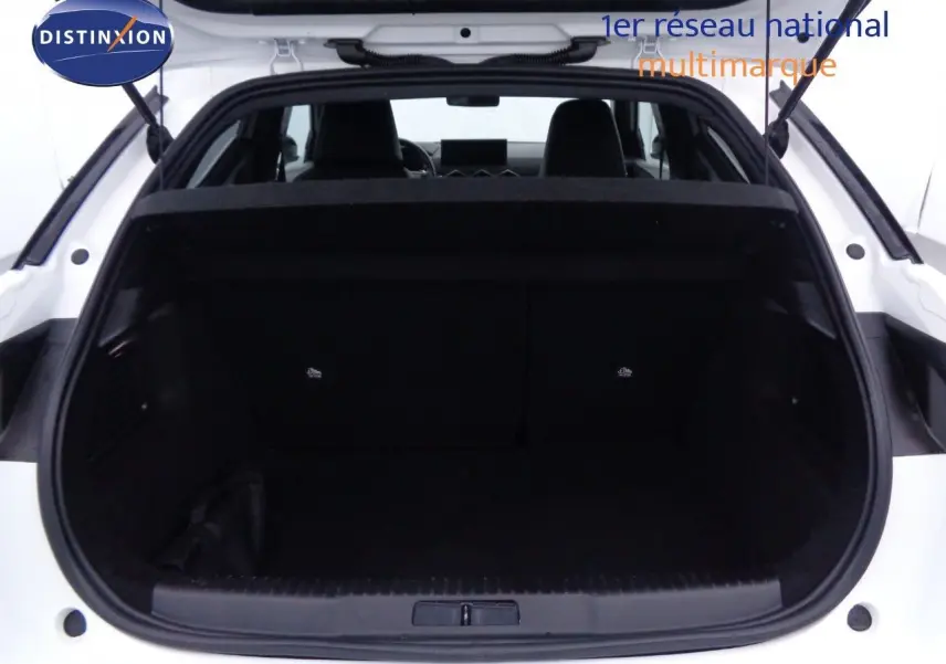 Coffre ouvert vu de l'arrière d'un DS3 Crossback blanc banquise, montrant l'espace de chargement intérieur noir.