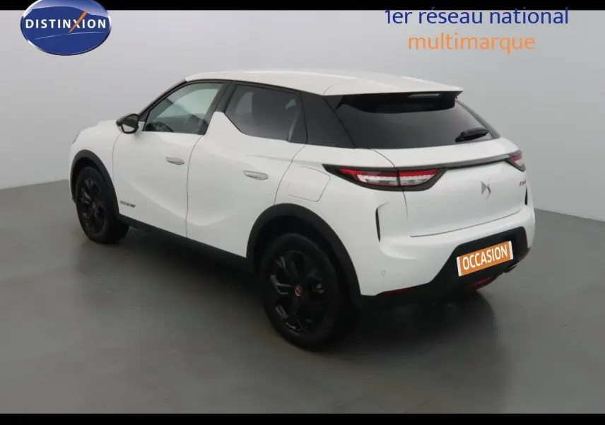 DS3 Crossback blanc banquise en 3/4 arrière droit, jantes noires et toit contrasté noir dans un studio.