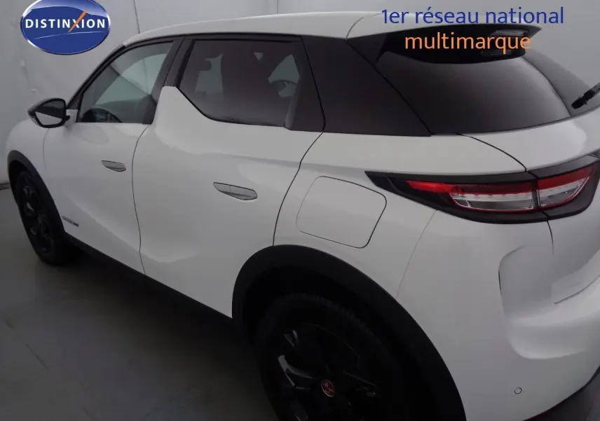 Vue 3/4 arrière droit du DS3 Crossback blanc banquise avec toit noir et jantes noires distinctives.