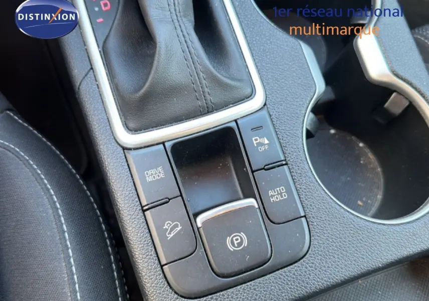 Gros plan sur la console centrale noire du Kia Sportage 2021, montrant la commande de boîte auto et les boutons de fonctions.