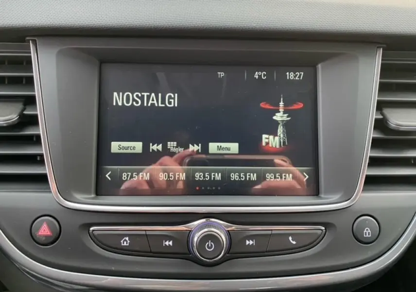 Écran tactile central de l’Opel Crossland 2022 affichant la radio FM sur fond noir avec commandes autour.