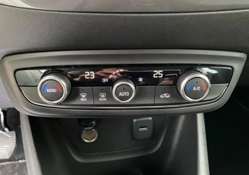 Panneau de commande de la climatisation automatique bi-zone de l’Opel Crossland, avec réglages numériques et boutons rotatifs.