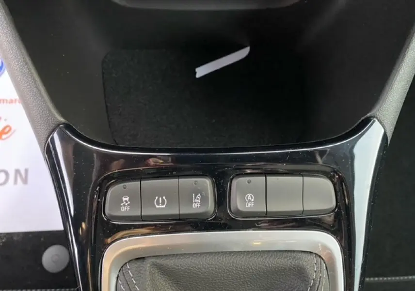 Gros plan sur la console centrale noire brillante de l'Opel Crossland 2022, montrant les boutons de contrôle et le soufflet de levier de vitesse.