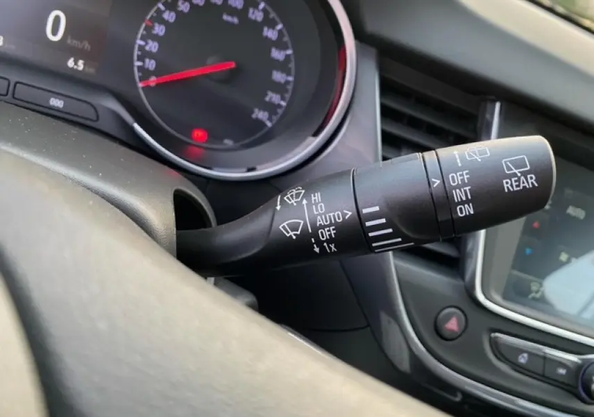Gros plan sur la commande des essuie-glaces à gauche du volant dans l’habitacle d’un Opel Crossland gris alu 2022.