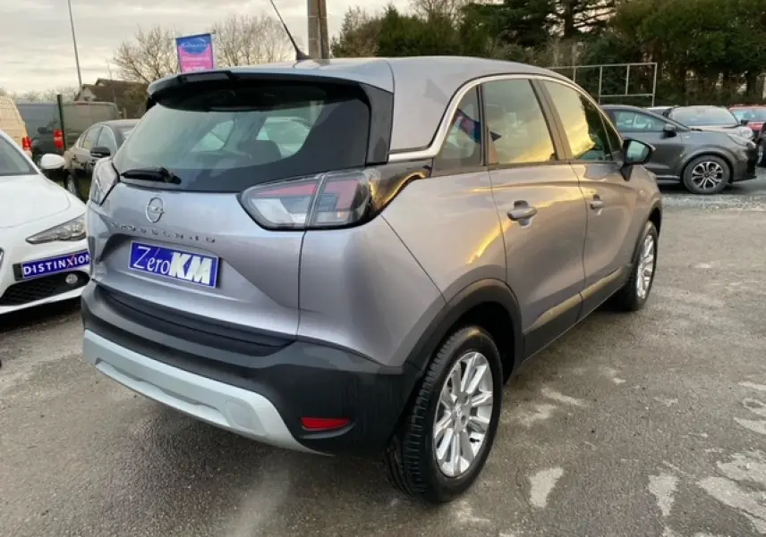 Opel Crossland gris alu en 3/4 arrière droit, avec coques de rétroviseurs noires et jantes alliage 16 pouces.