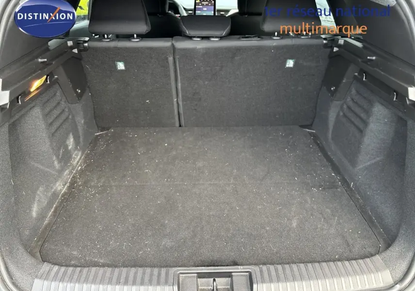 Vue intérieure du coffre spacieux du Renault Symbioz blanc nacré, avec banquette arrière en tissu noir visible.