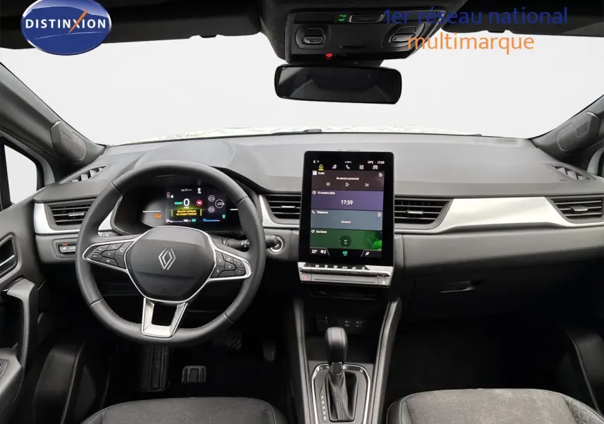 Vue intérieure avant du Renault Symbioz blanc nacré, tableau de bord moderne avec écran tactile vertical et volant multifonction.