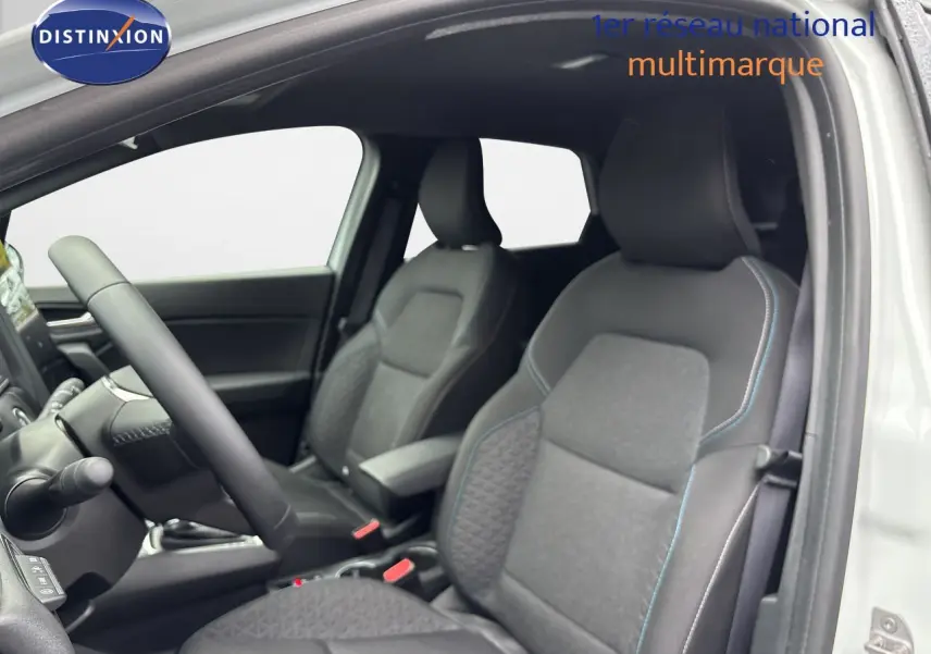 Intérieur de la Renault Symbioz 2025, vue côté gauche sur les sièges tissu noir avec surpiqûres bleues et volant.