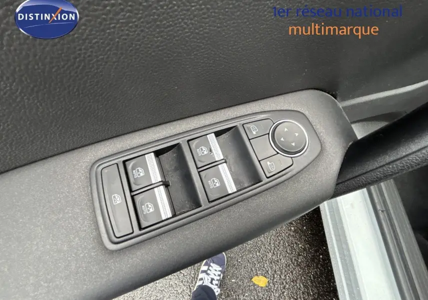 Gros plan sur les commandes de lève-vitres et rétroviseurs sur la porte intérieure d'une Renault Symbioz blanc nacré.
