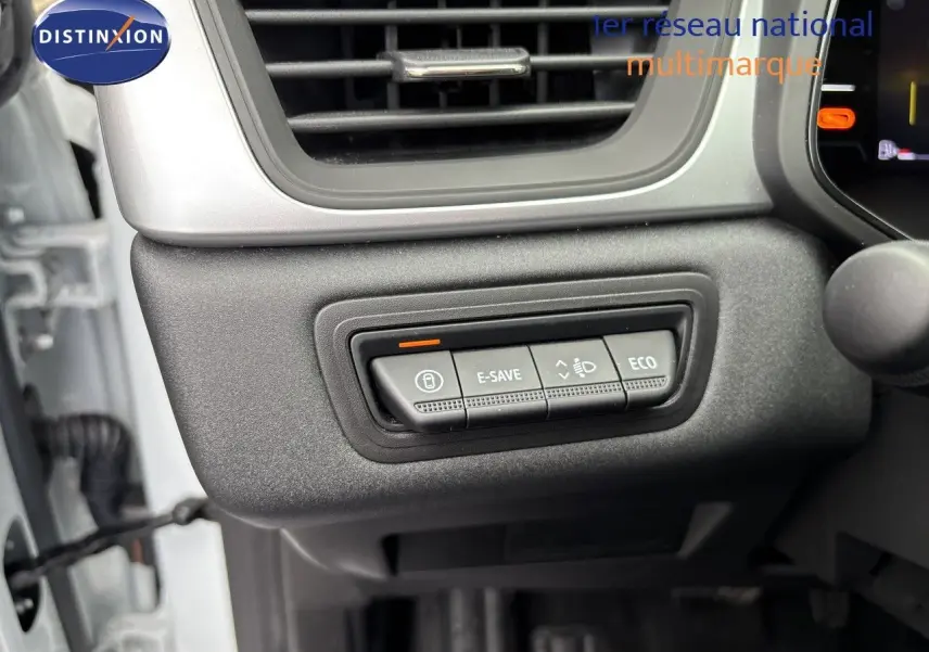 Gros plan sur les commandes de mode de conduite E-SAVE et ECO dans l'habitacle d'une Renault Symbioz blanc nacré.