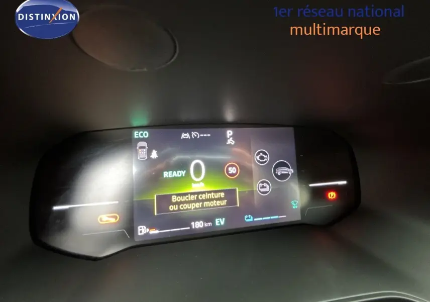 Tableau de bord numérique du Renault Symbioz blanc nacré, affichant la vitesse à 0 km/h et alertes de sécurité.