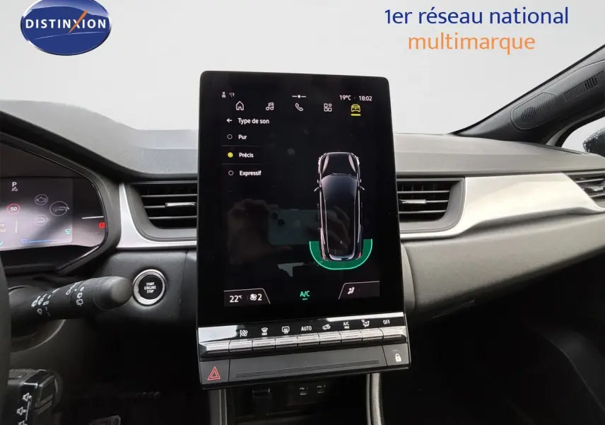 Vue intérieure du tableau de bord de la Renault Symbioz blanc nacré, avec écran tactile central et commandes climatisation.