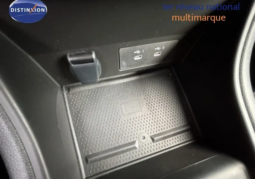 Gros plan sur la console centrale noire avec ports USB et surface antidérapante dans une Renault Symbioz blanc nacré.