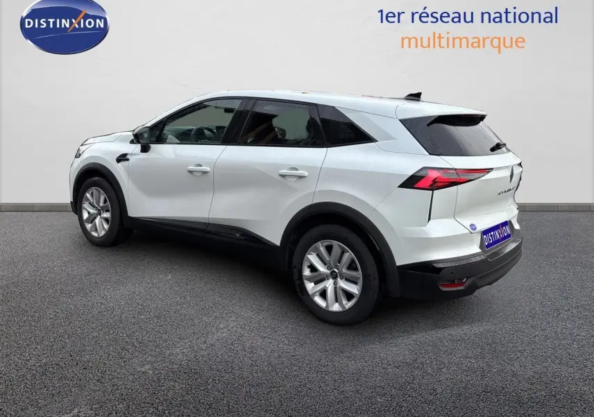Renault Symbioz blanc nacré métal en vue 3/4 arrière droit, avec feux arrière LED et jantes alliage.