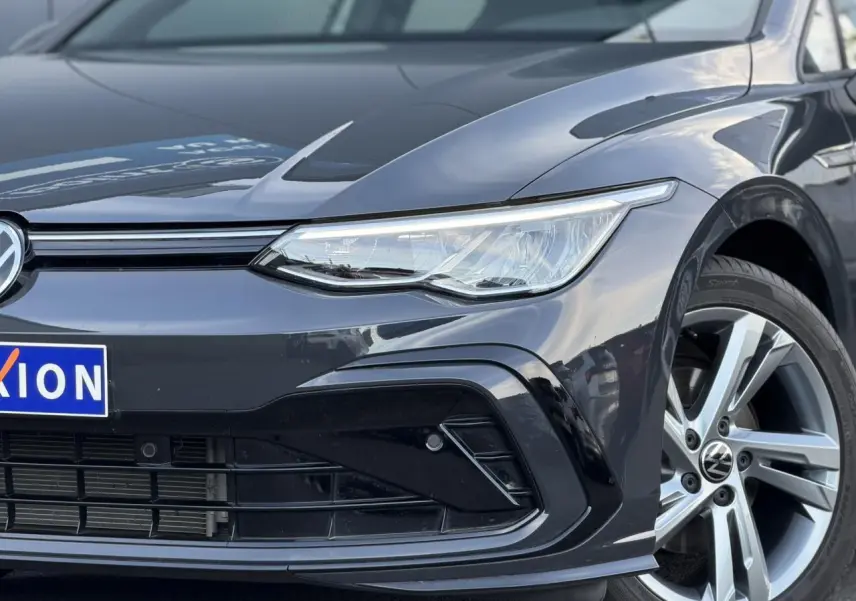 Gros plan sur l'avant droit de la Volkswagen Golf 8 R-Line 2024 en Gris Urano avec projecteur LED et jante alliage Valencia.