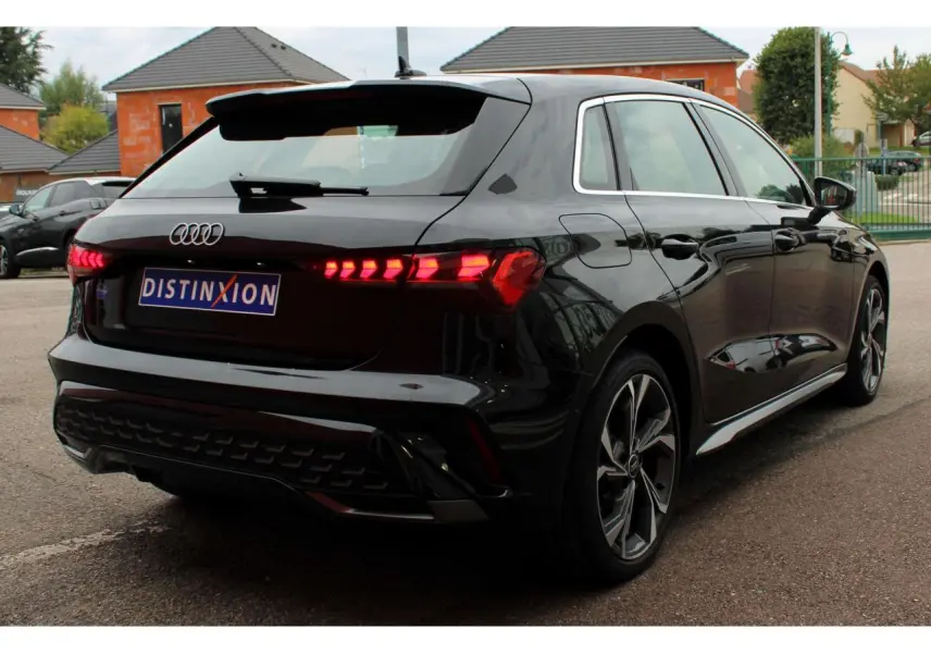 Audi A3 Sportback noir mito métal vue 3/4 arrière droit avec feux arrière LED et jantes alliage 18 pouces.