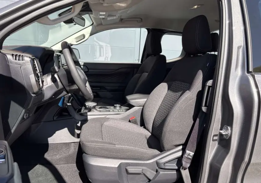 Vue intérieure côté conducteur du Ford Ranger gris carbone 2026, montrant les sièges avant et le tableau de bord.