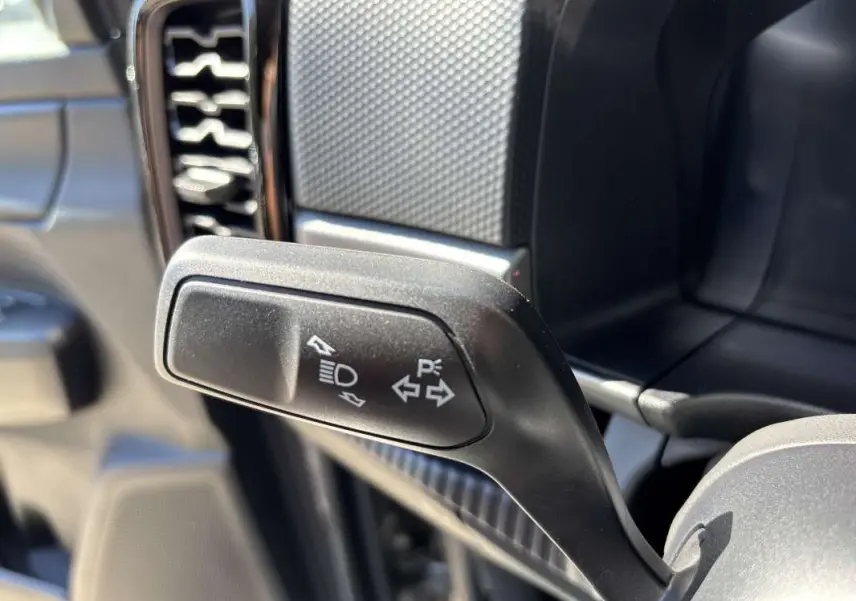 Gros plan sur la manette de clignotant noire à gauche du volant dans l'habitacle du Ford Ranger gris carbone 2026.