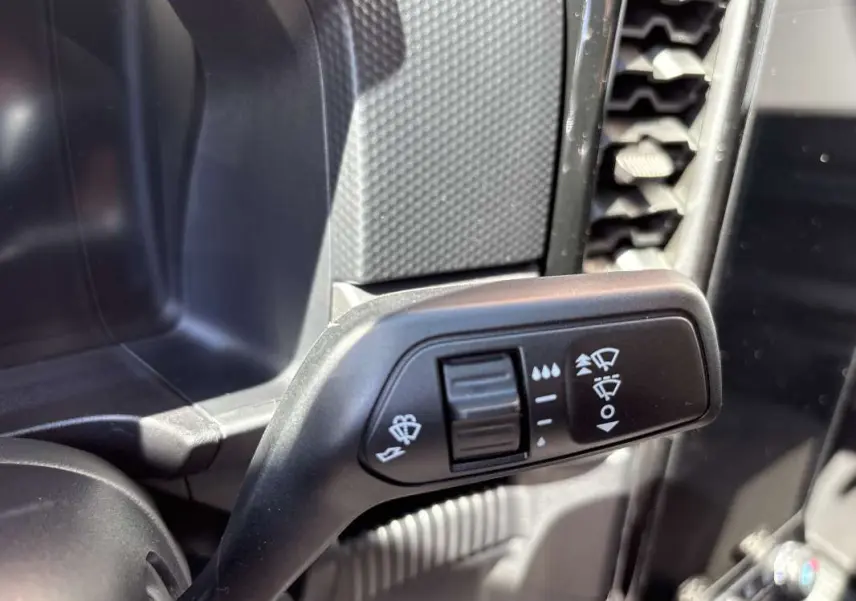 Gros plan sur la commande des essuie-glaces à gauche du volant dans l’habitacle du Ford Ranger gris carbone 2026.