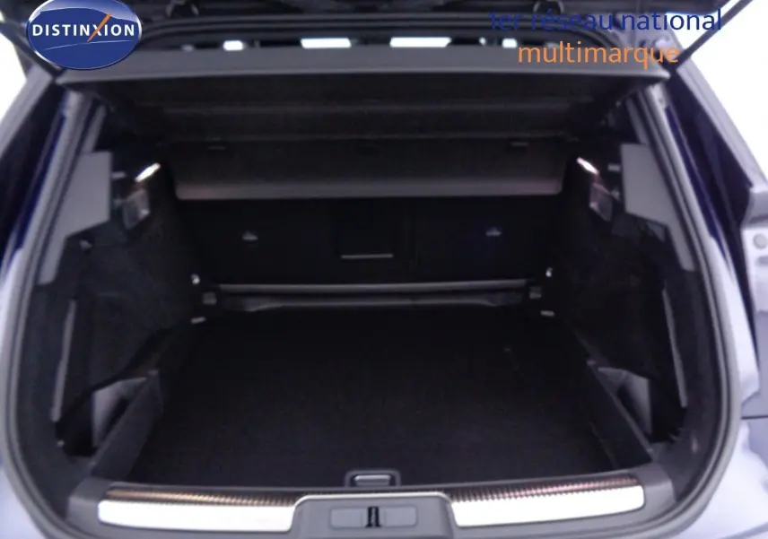 Coffre ouvert du DS7 Crossback bleu encre métal, vue arrière montrant l'espace de chargement spacieux et bien fini.