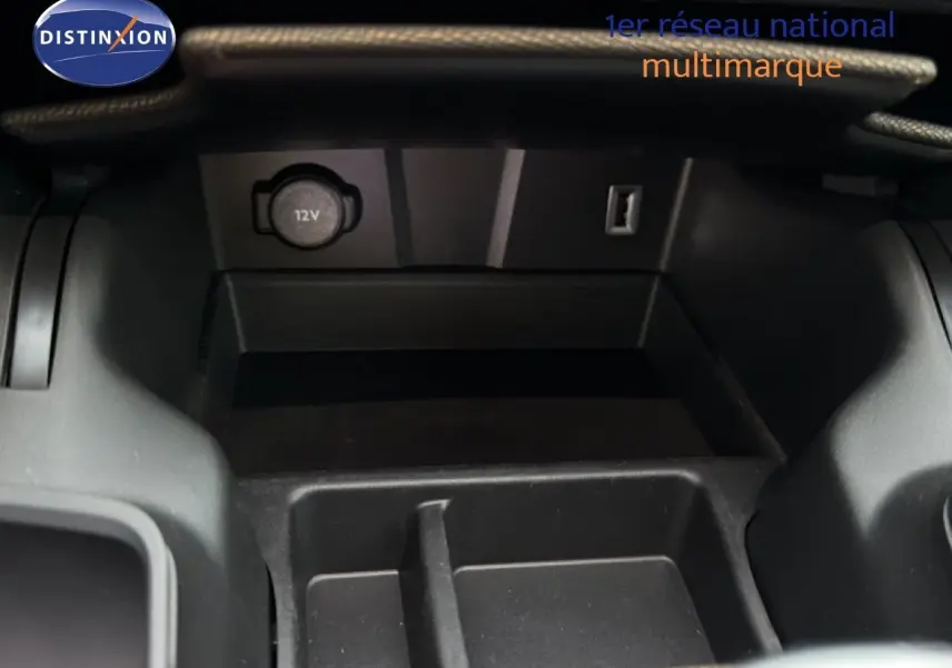 Gros plan sur la console centrale du DS7 Crossback bleu encre, montrant une prise 12V et un port USB.