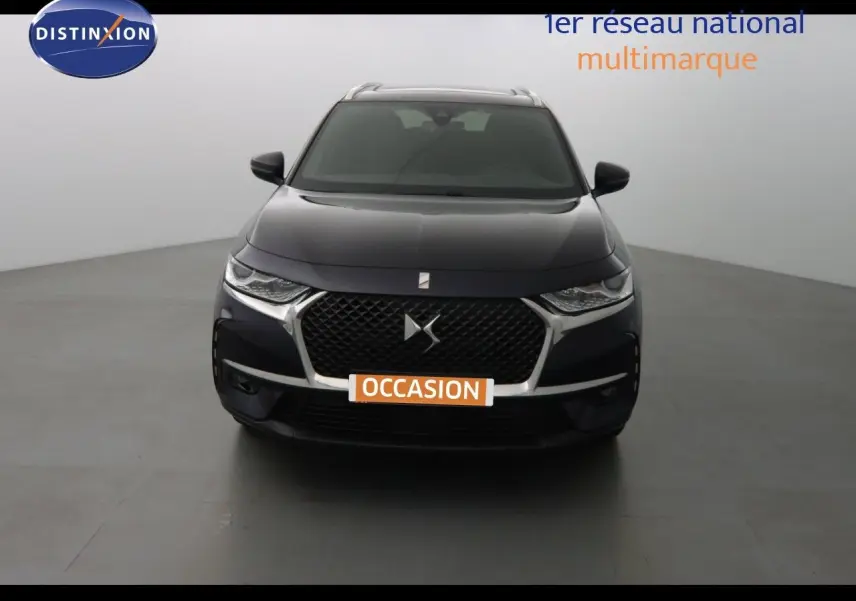 Vue frontale d'un DS7 Crossback hybride bleu encre métal avec calandre distinctive et phares LED fins.