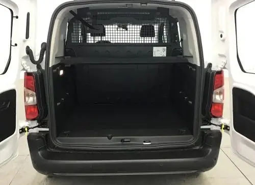 Vue arrière ouverte du Peugeot Rifter blanc Banquise 2025, montrant l’espace de chargement avec cloison de sécurité métallique.