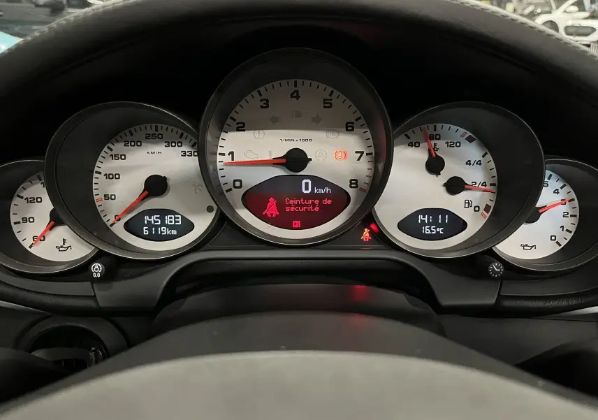 Vue rapprochée du tableau de bord argenté de la Porsche 911 Targa 997 Carrera 4S avec affichage numérique et compte-tours central.