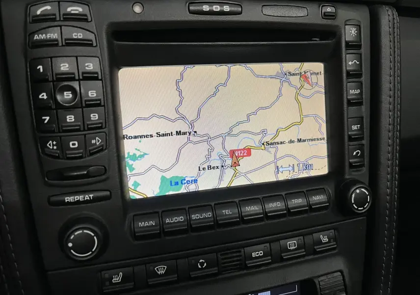 Vue rapprochée de l’écran GPS central et des commandes noires du tableau de bord de la Porsche 911 Targa 997 Carrera 4S 2006.