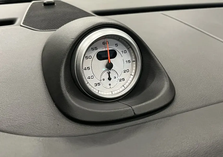 Gros plan sur le chronomètre argenté du tableau de bord du Porsche 911 Targa 997 Carrera 4S noir métallisé.