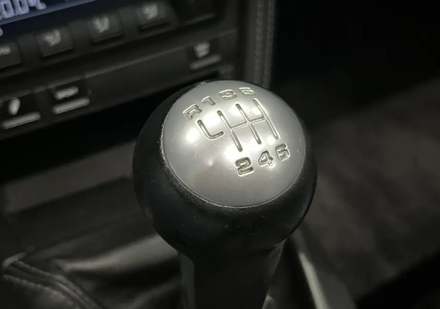 Gros plan sur le levier de vitesse manuel argenté et noir de la Porsche 911 Targa 997 Carrera 4S de 2006.