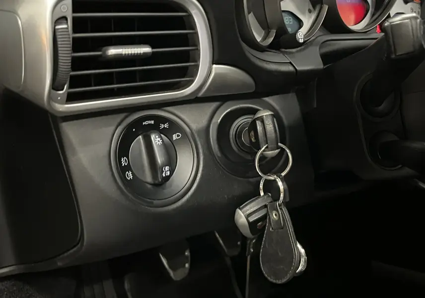 Gros plan sur le tableau de bord noir de la Porsche 911 Targa 997 avec clé insérée dans le contacteur.