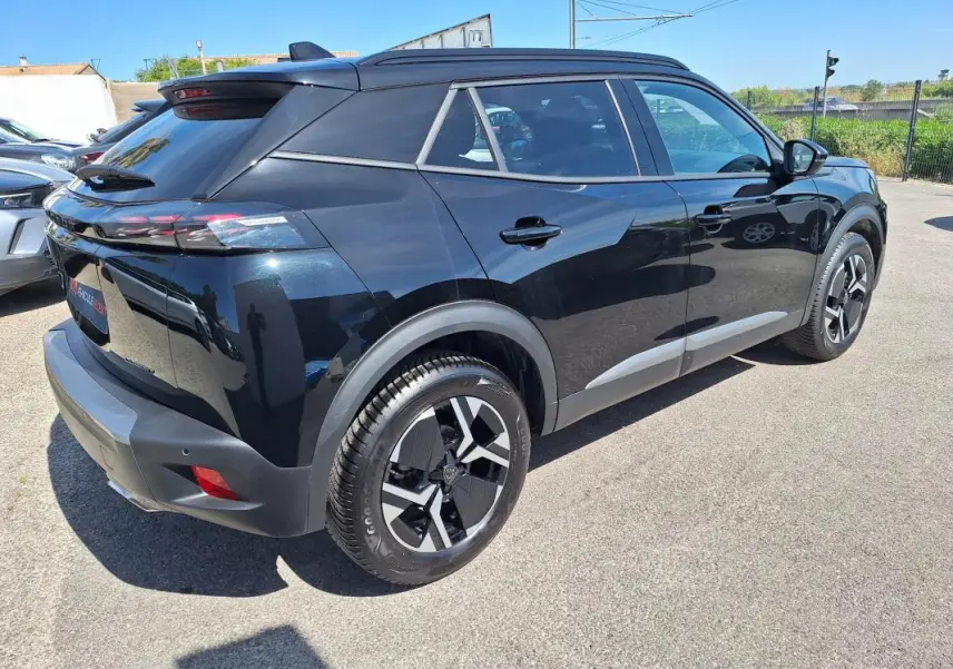 Peugeot 2008 Hybrid noir vue 3/4 arrière droit, avec barres de toit et jantes alliage 17 pouces.