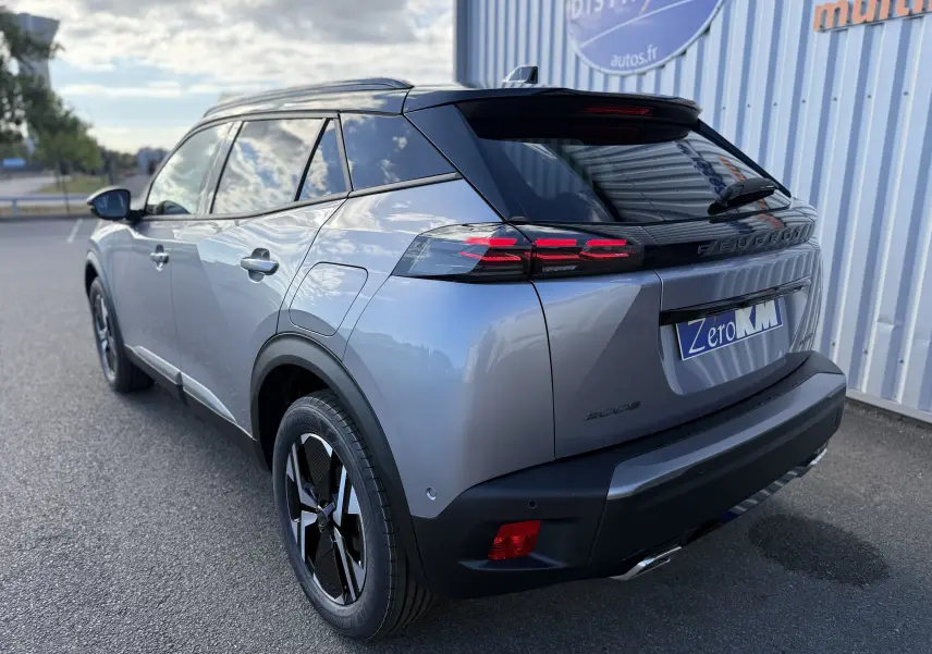Vue 3/4 arrière droite d’un Peugeot 2008 Hybrid 145 gris Artense avec toit noir et feux arrière LED distinctifs.