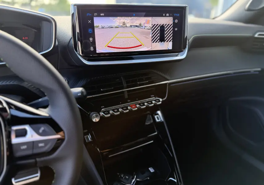 Vue intérieure du tableau de bord du Peugeot 2008 Hybrid 145 GT, avec écran central affichant la caméra de recul.