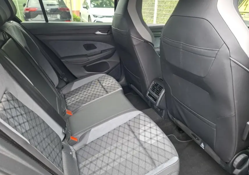 Vue intérieure arrière côté droit de la Volkswagen Golf 8 R-Line 2024 avec sellerie tissu et ArtVelours gris à motifs.